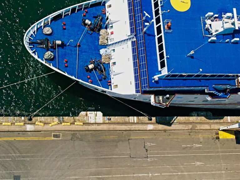 Bird's eye view of ship bow with a blue deck. Barcelona Spain harbor.